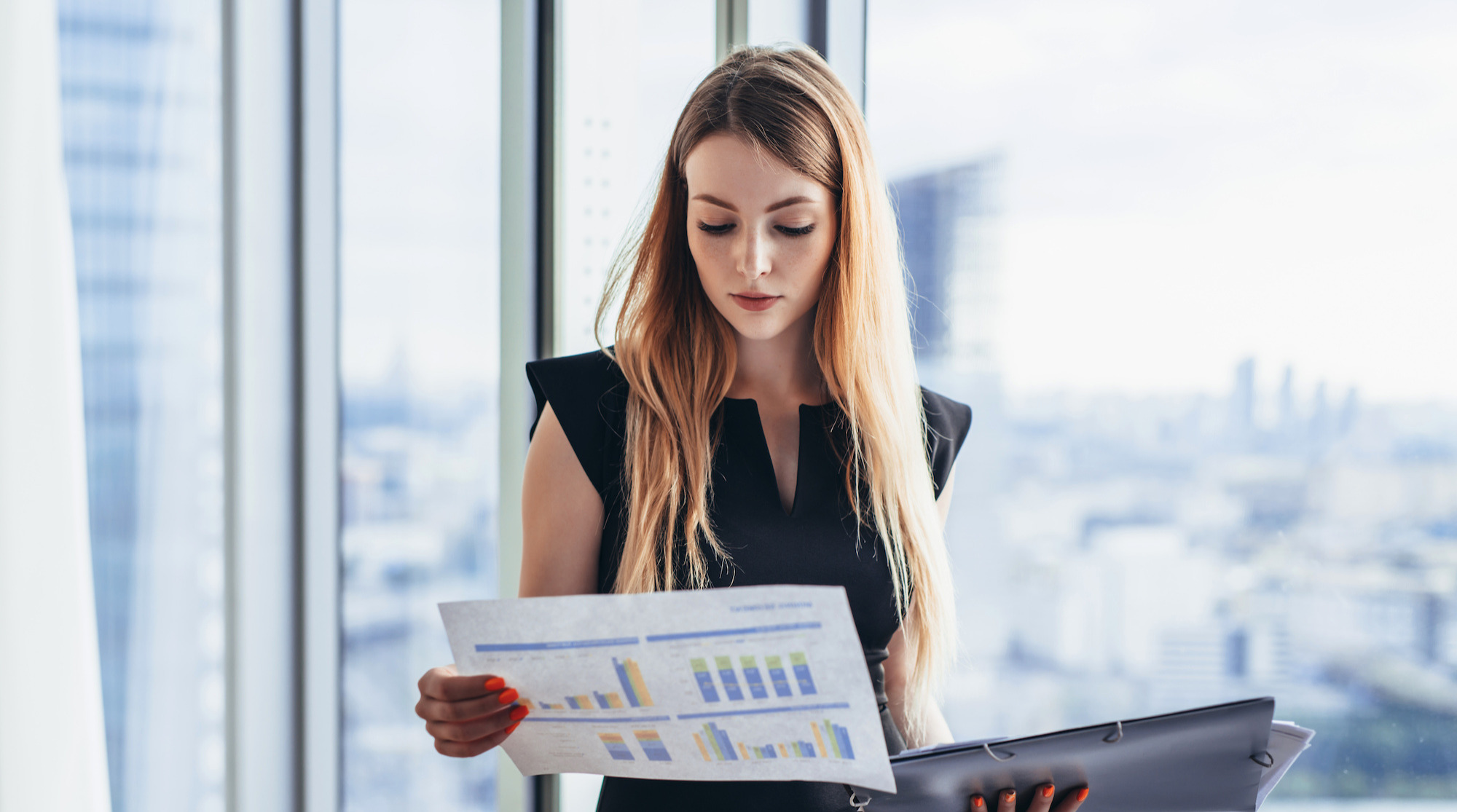 A female looking at paper with charts