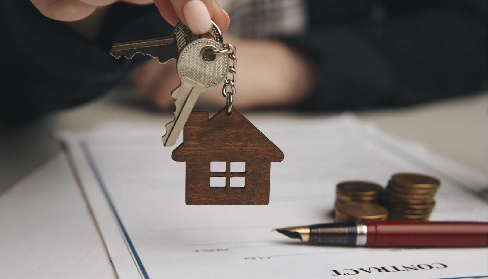 A close up of a wooden house keychain