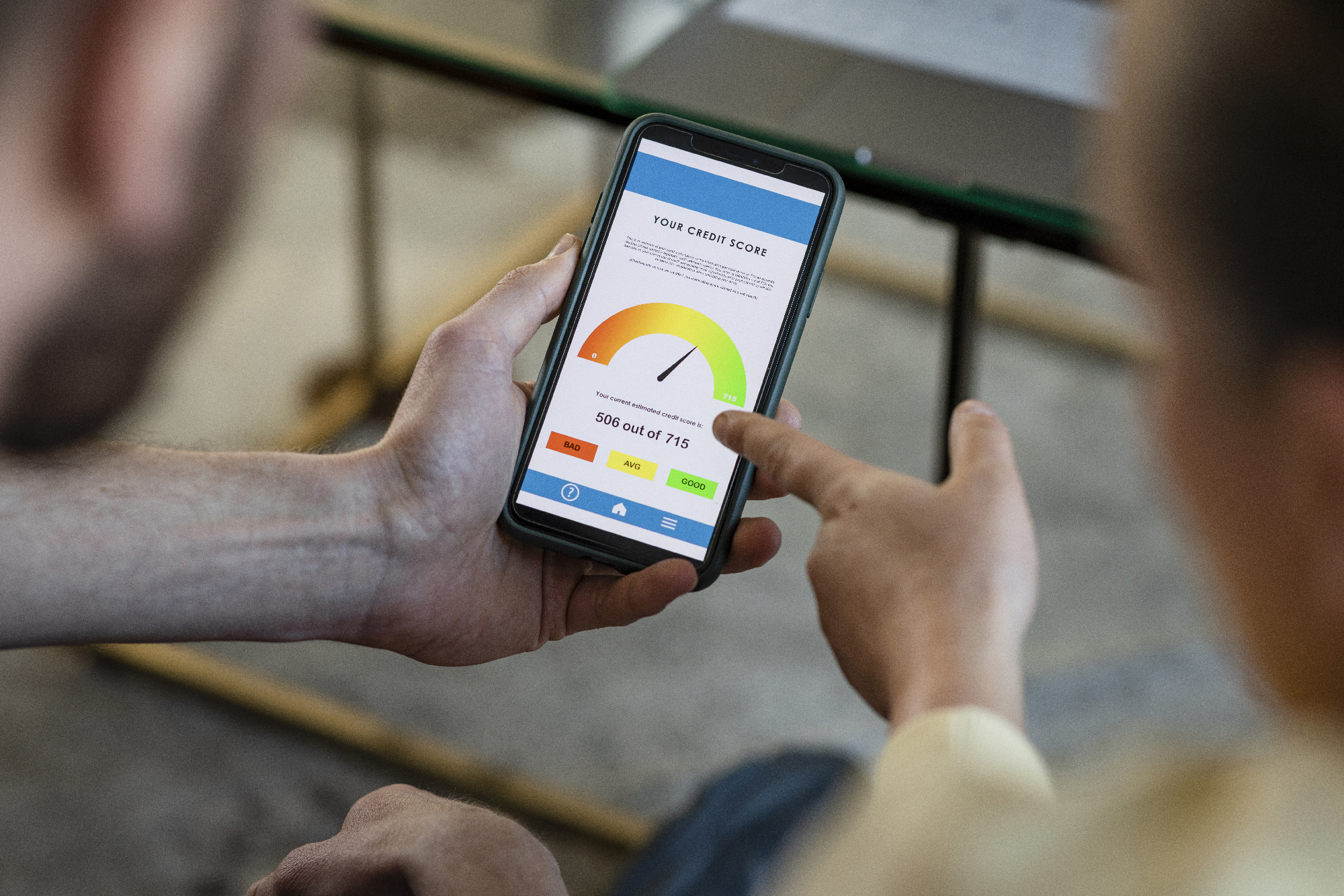People looking at a phone with credit score information