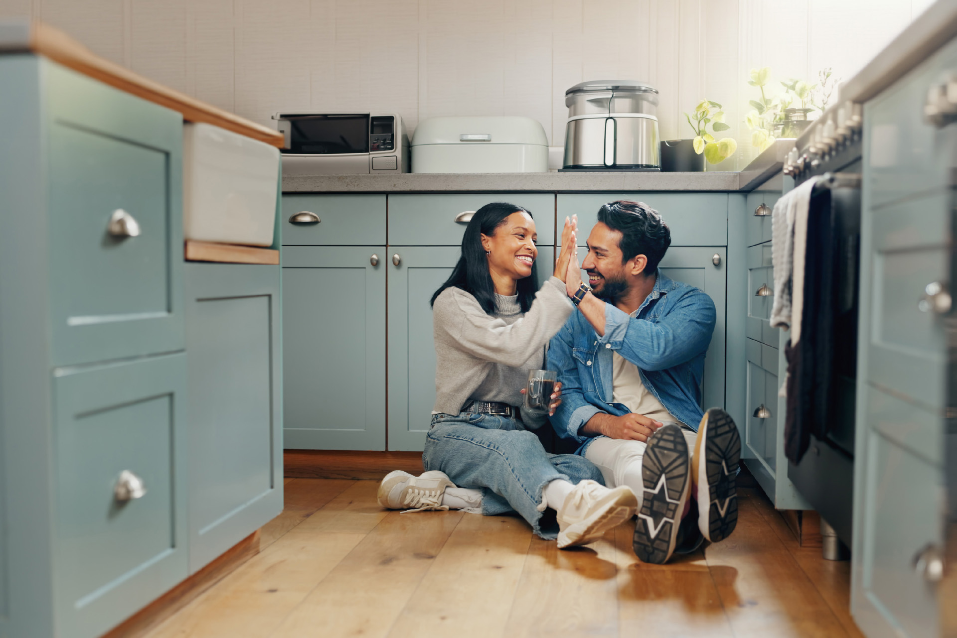 Smiling couple sitting on the floor in a kitchen