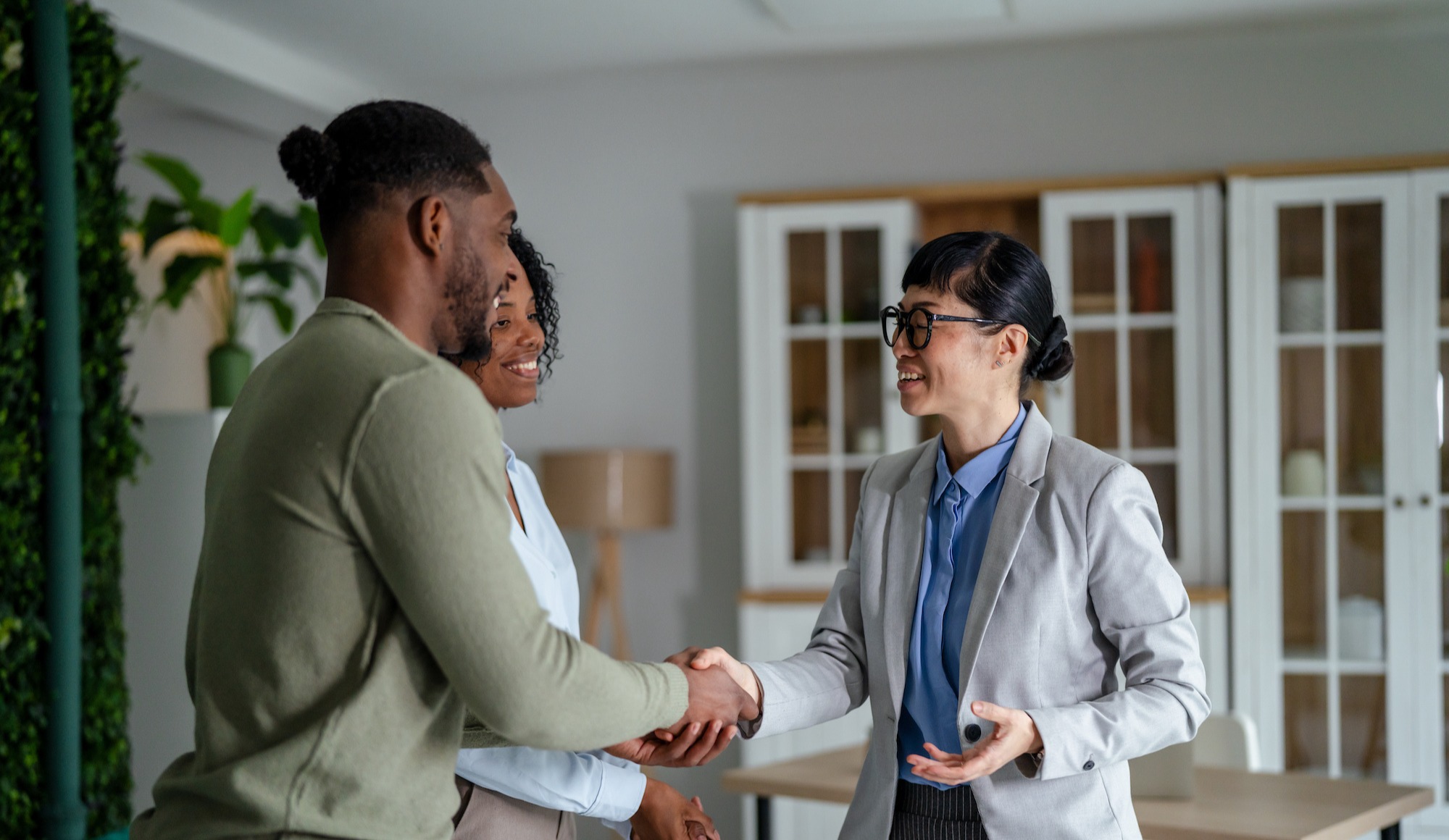Woman shaking hands with a couple