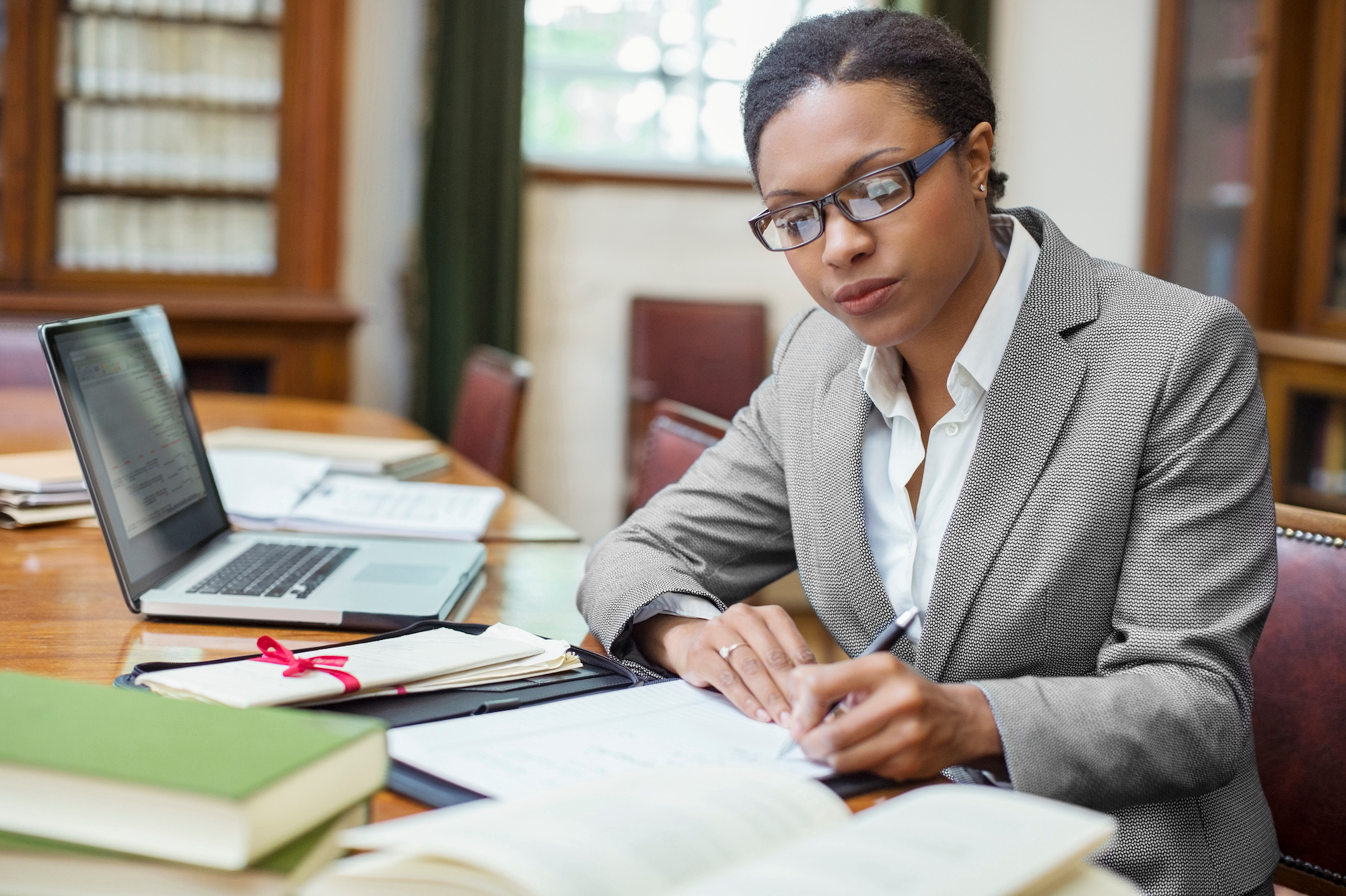 Woman sitting on a desk and signing documents
