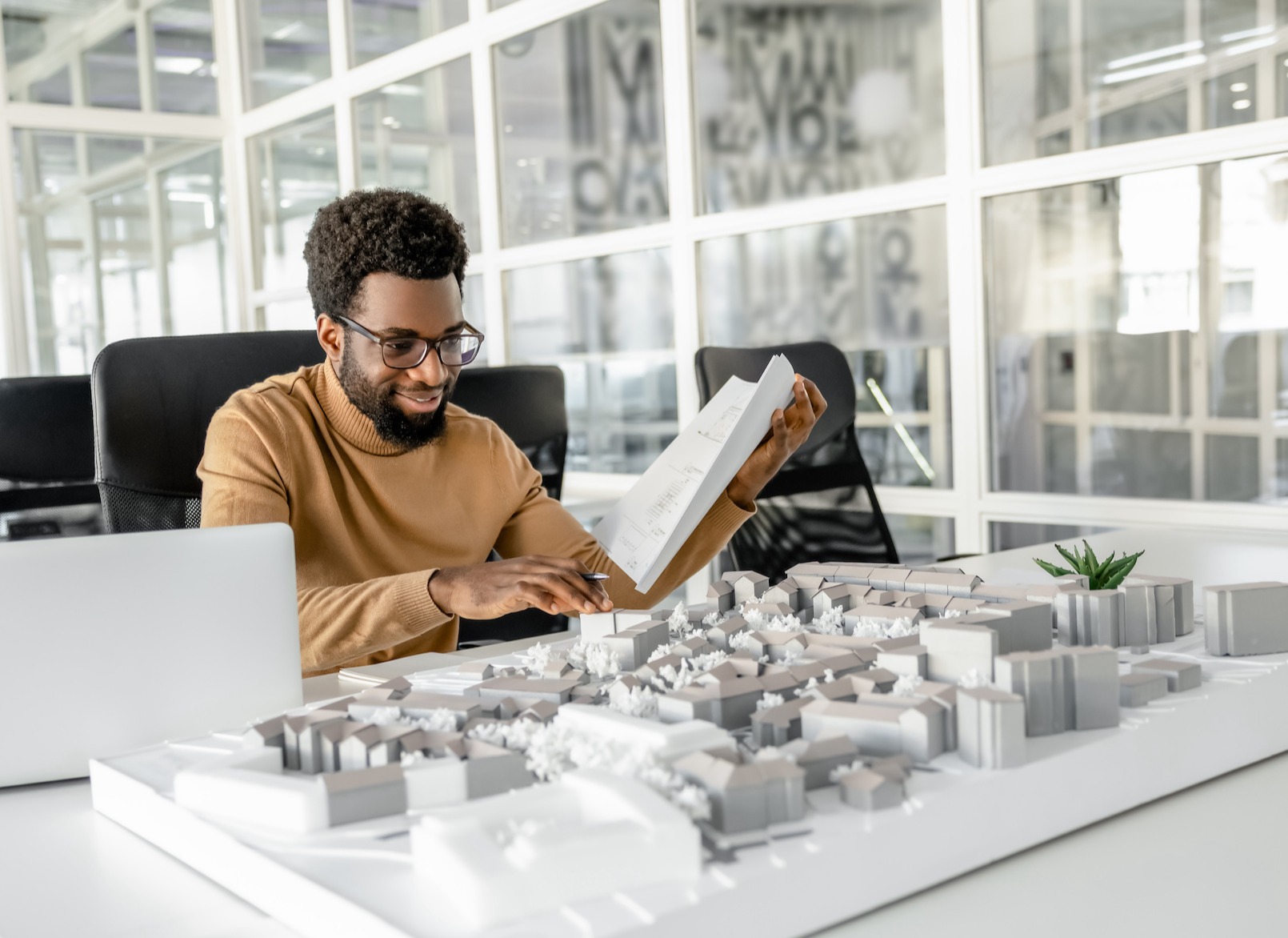 Architect working on miniature project and looking inspired