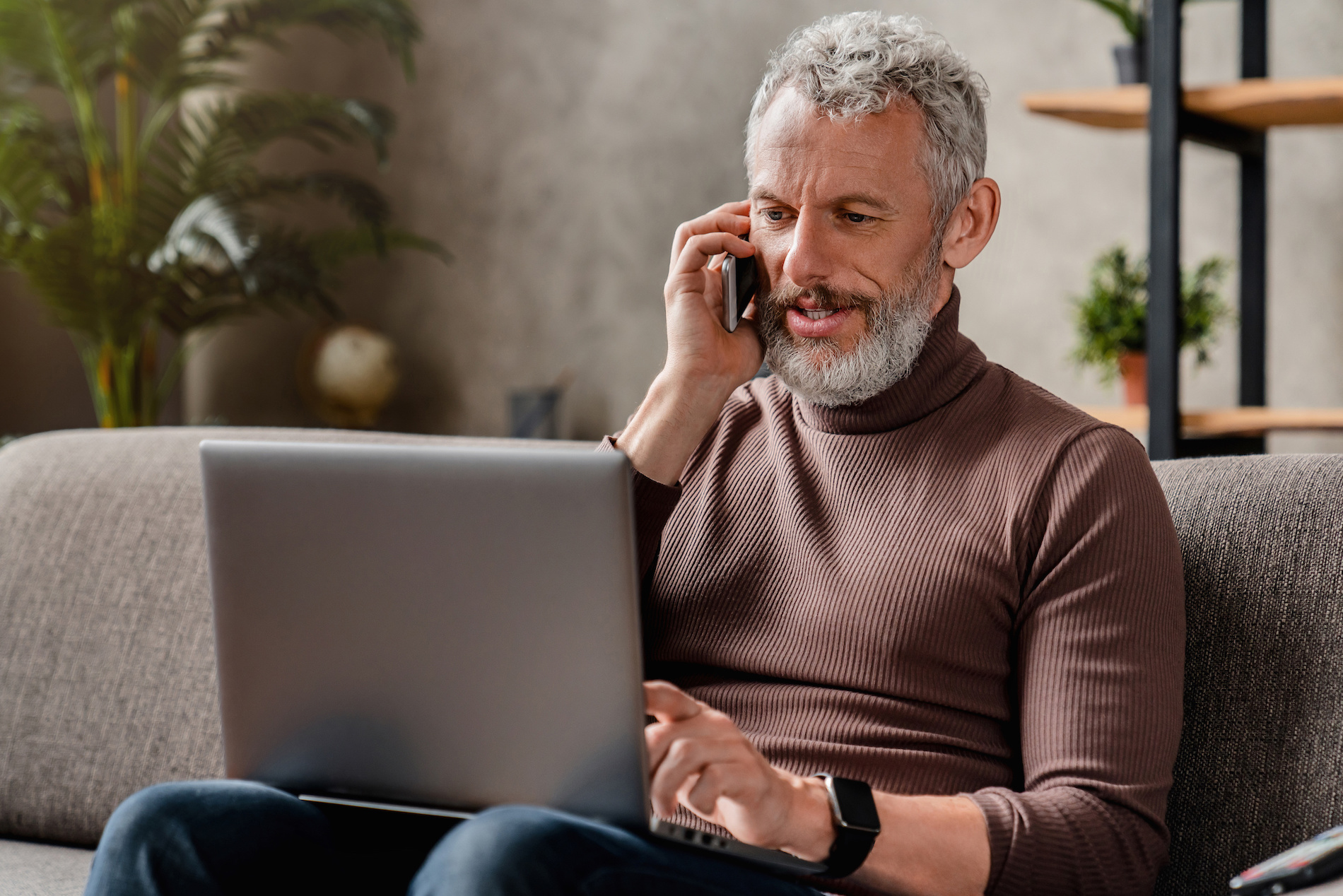 Businessman looking at laptop and talking on the phone