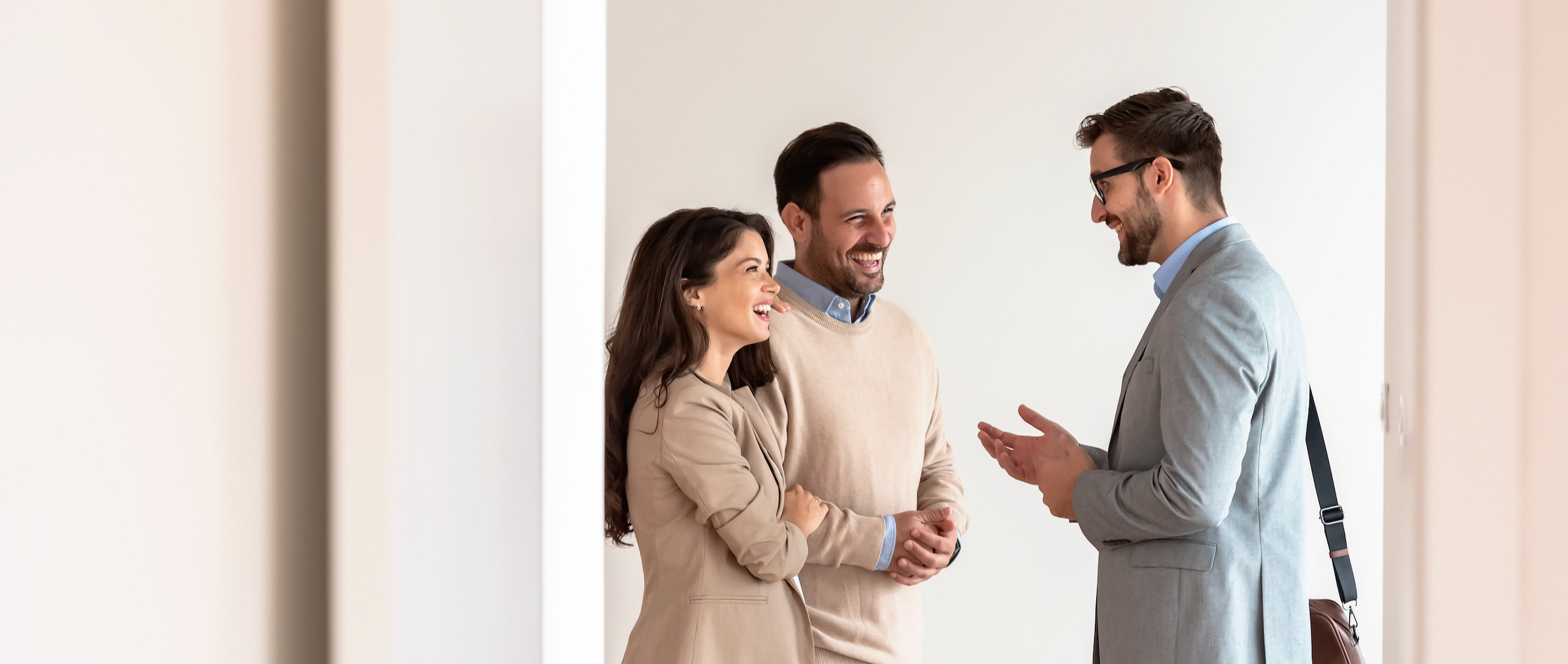 A couple speaking with a broker in an empty room