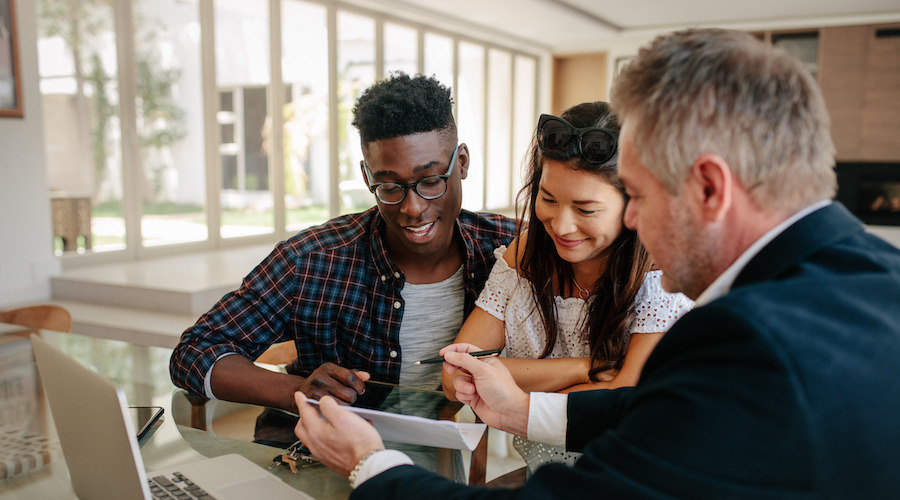 A broker showing documents to a couple