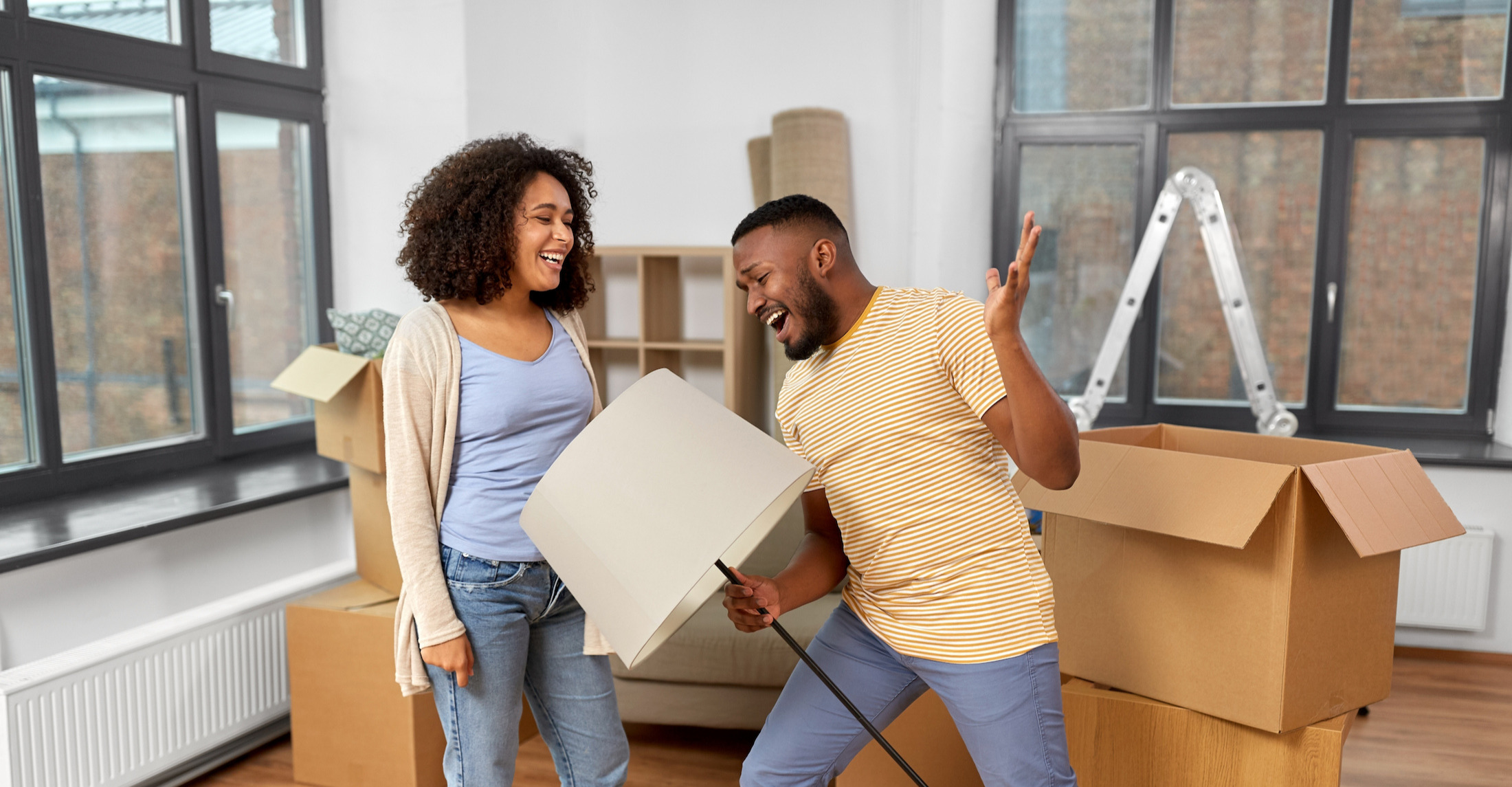 A happy couple in a living room with cardboard boxes