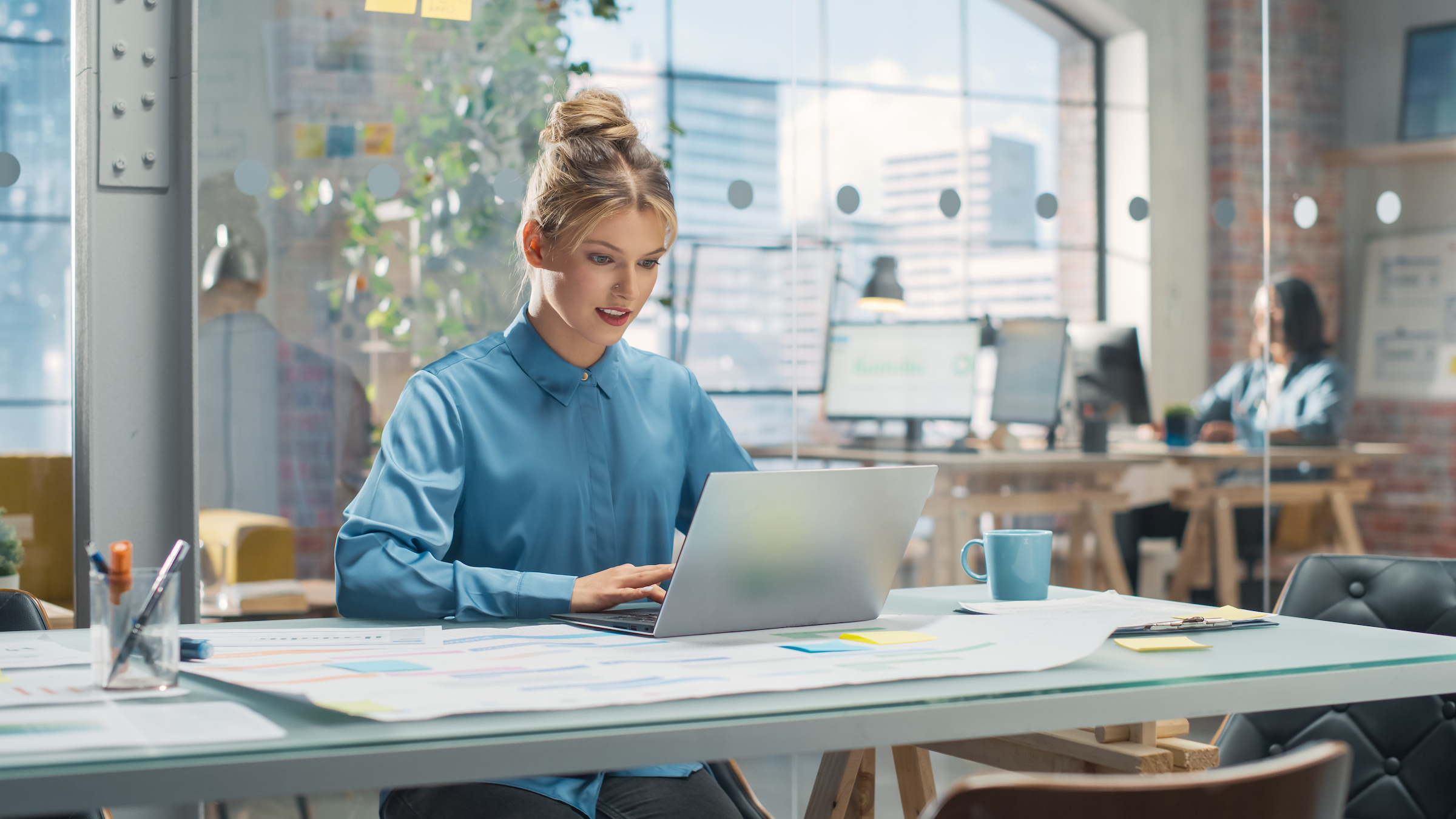 A female working on a laptop in an open space office