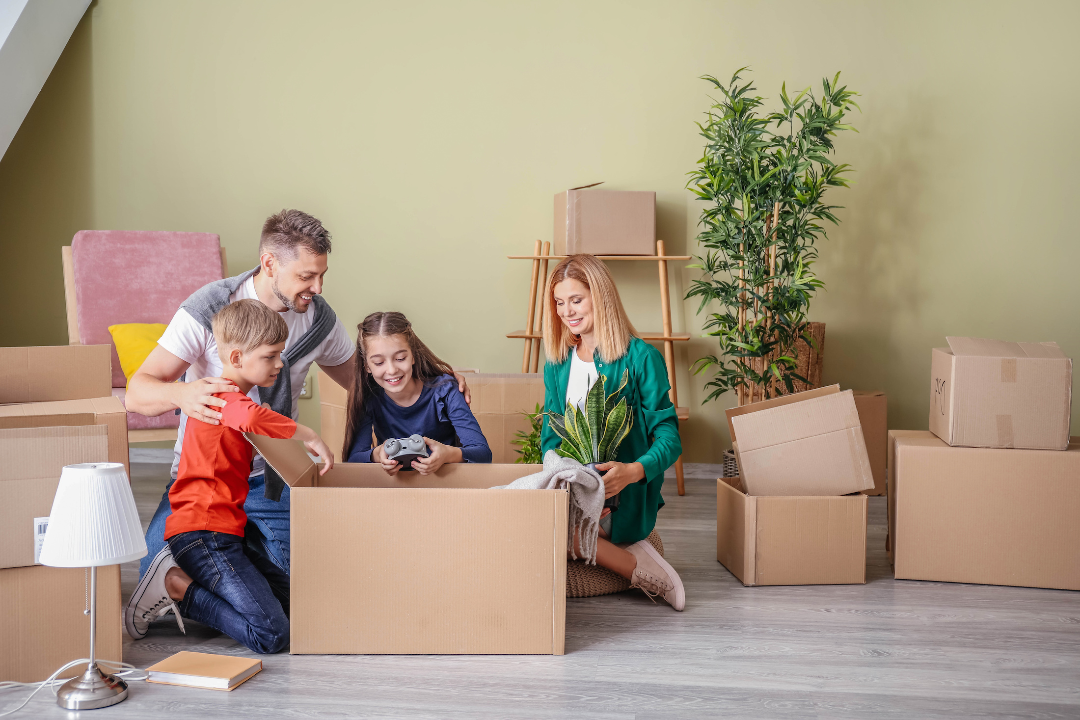 A family of four unpacking boxes in a new home