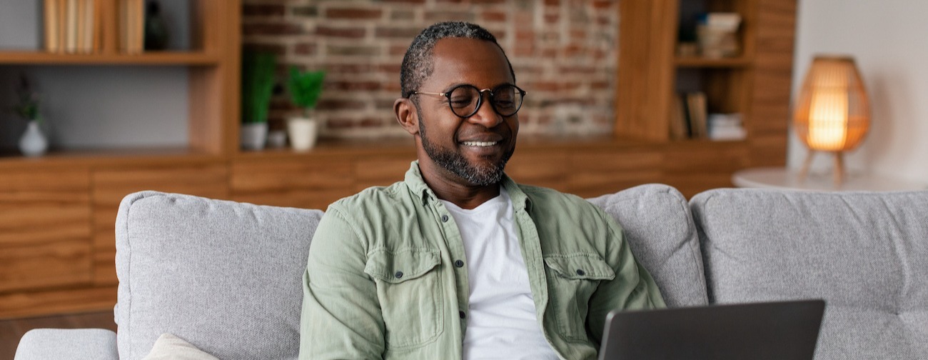 A male with a laptop in a living room
