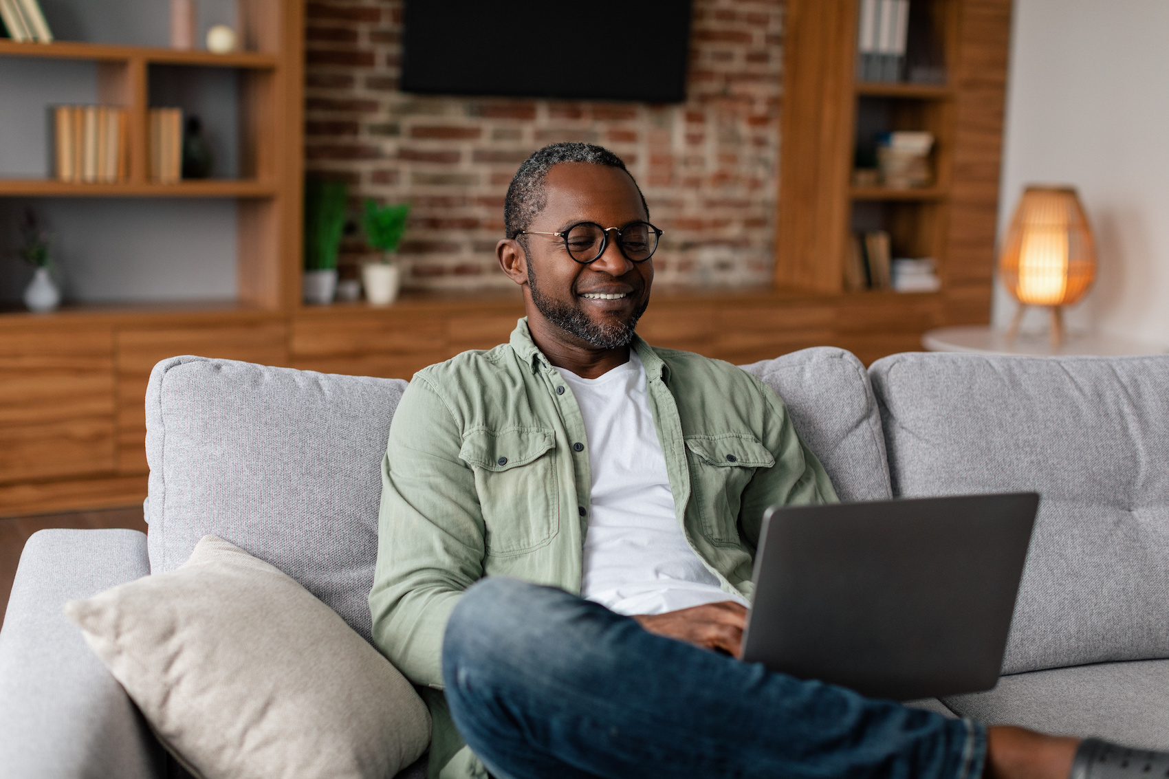 A male with a laptop in a living room