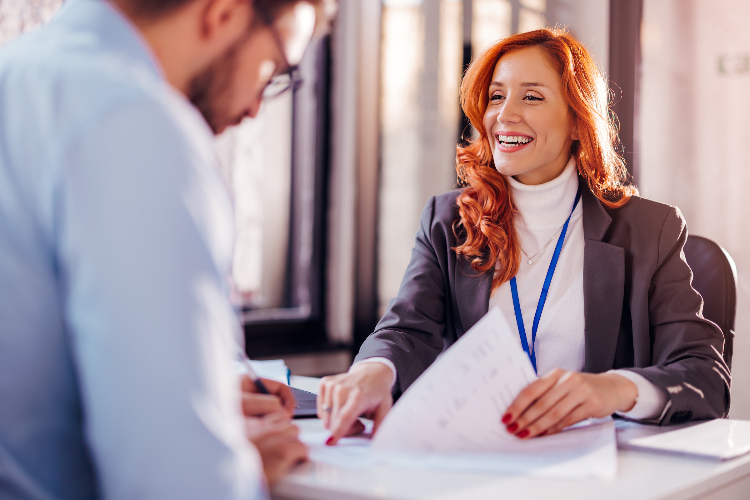 An employee showing a client where to sign a document