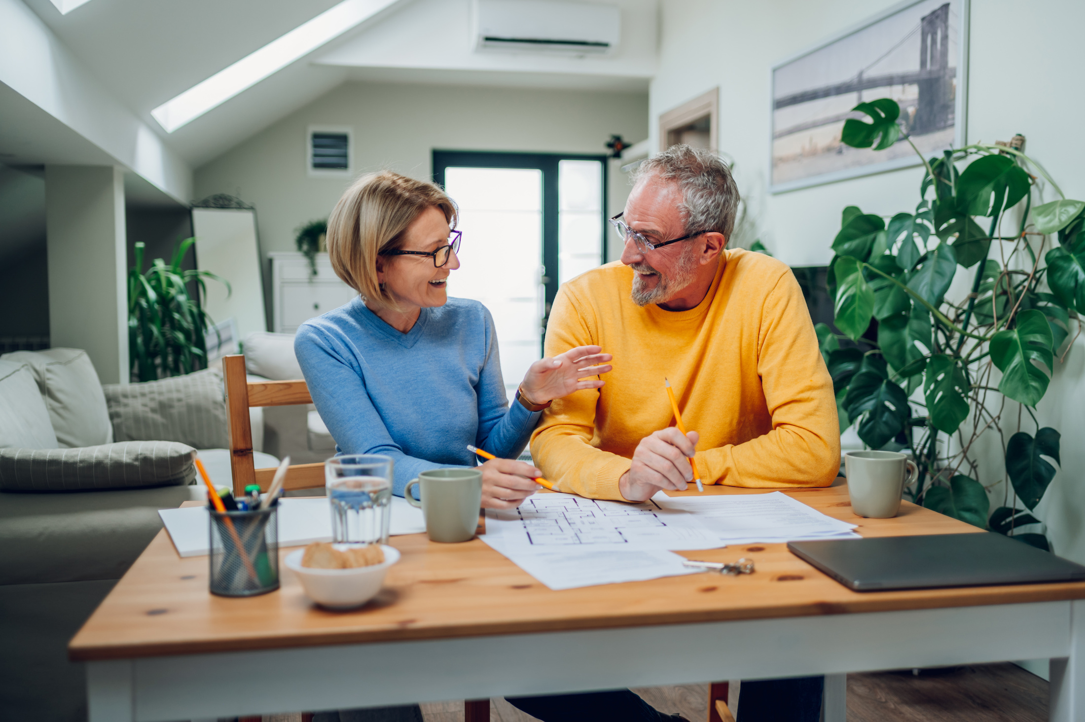 A smiling middle aged couple looking at house plan pappers