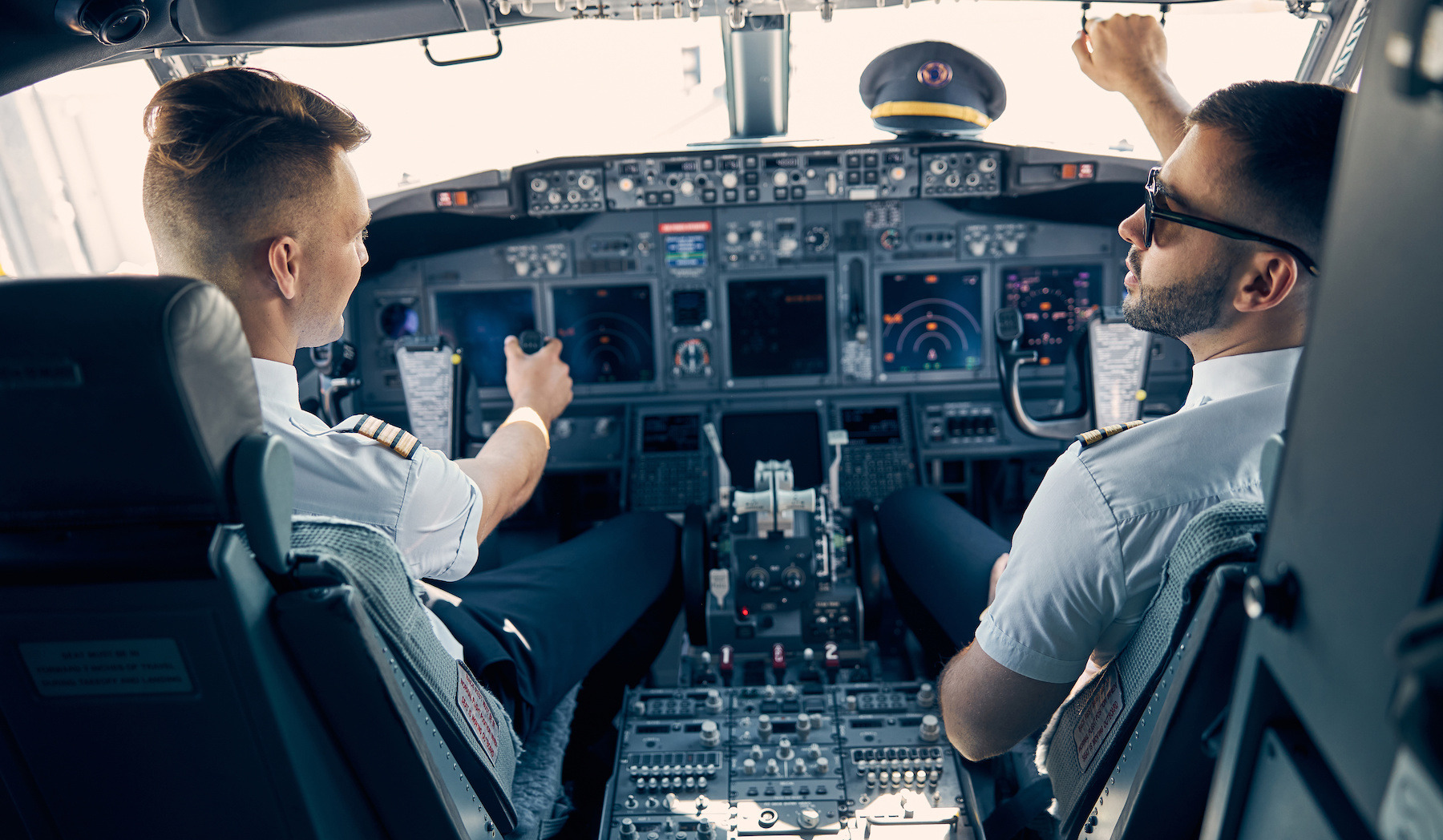 Two male pilots sitting in an airplane cockpit