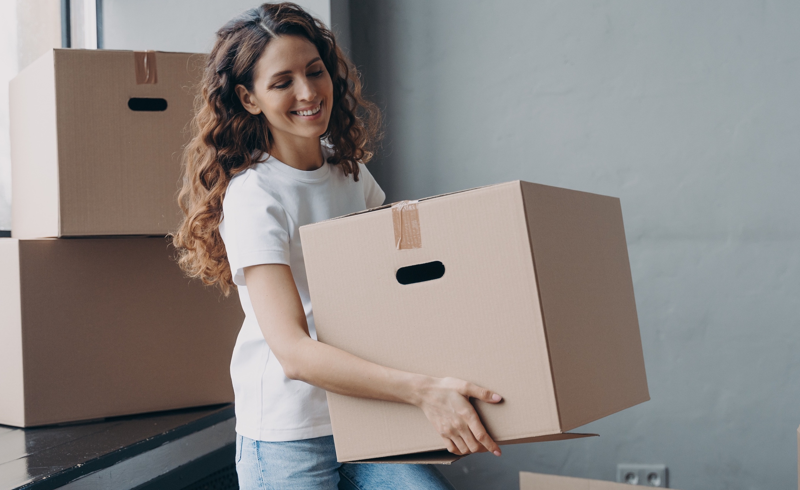 Woman holding a box in an empty room