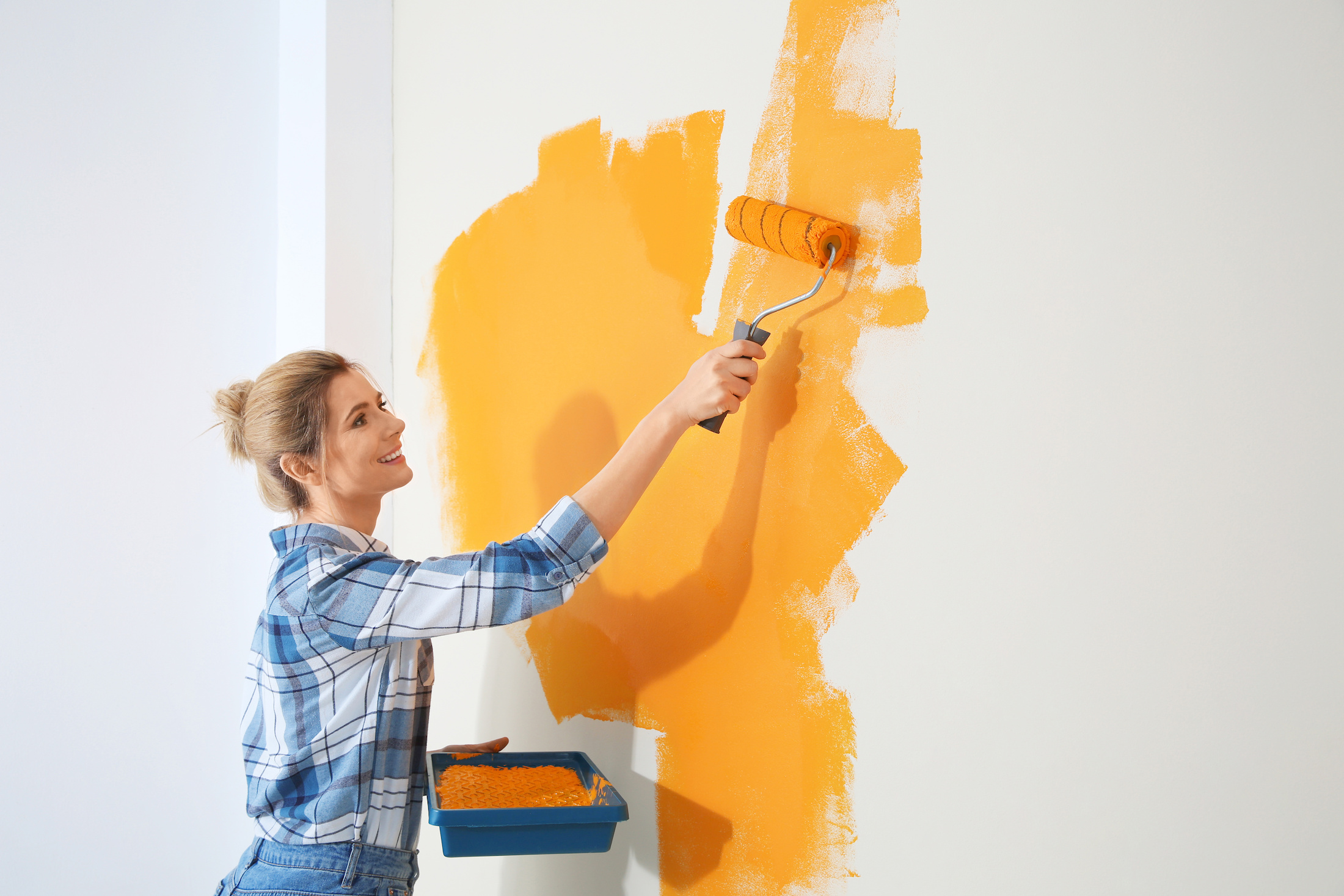 Woman painting a wall in orange