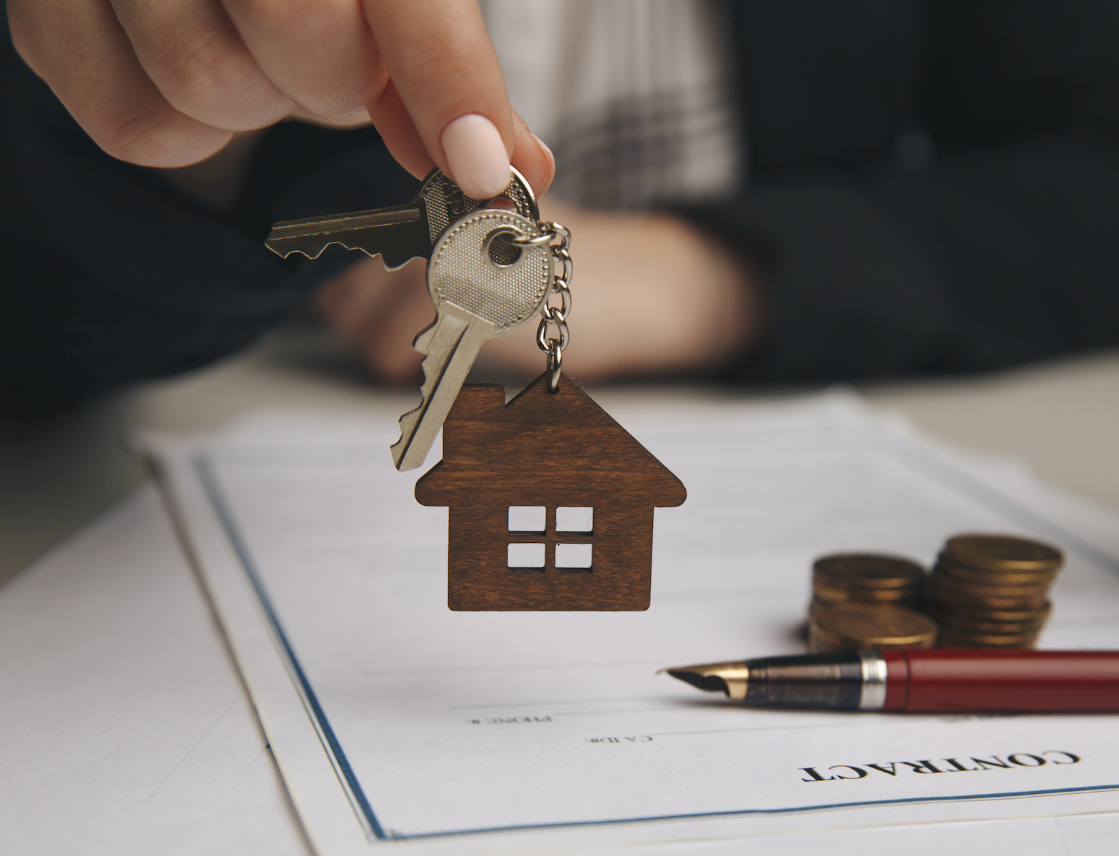 A close up of a wooden house keychain