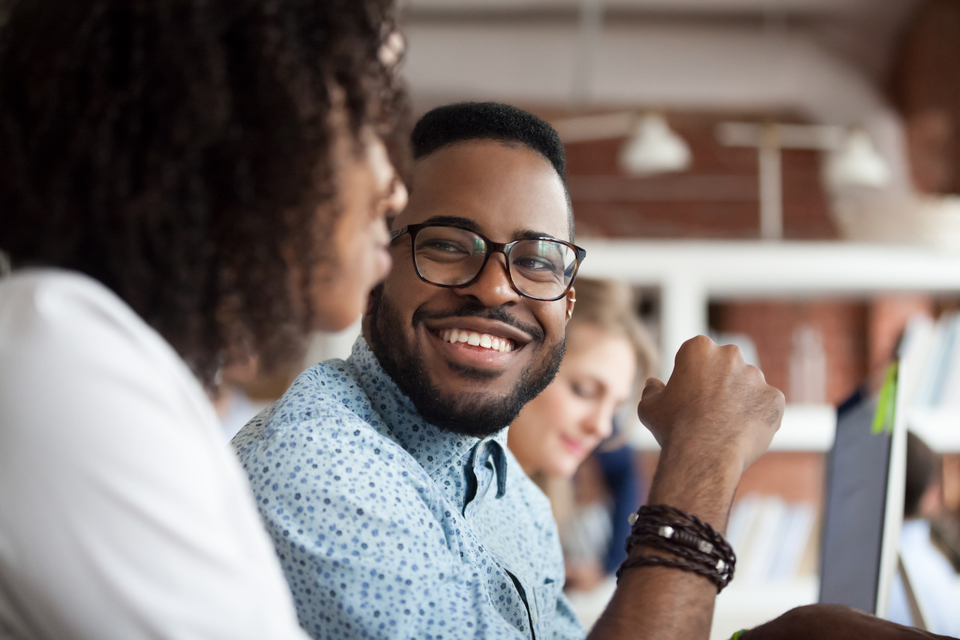 Smiling man looking at female colleague in office