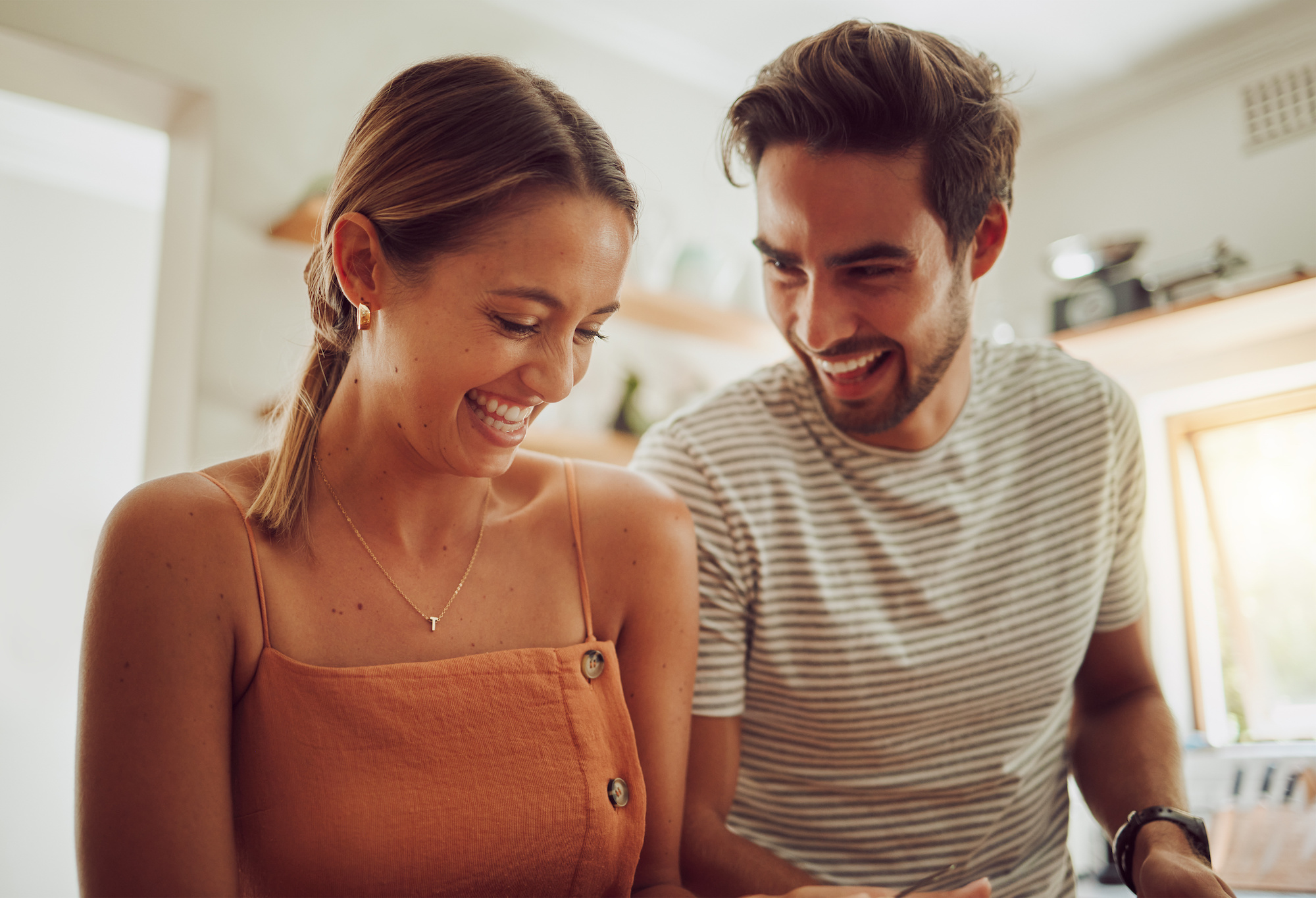 Couple laughing in a kitchen