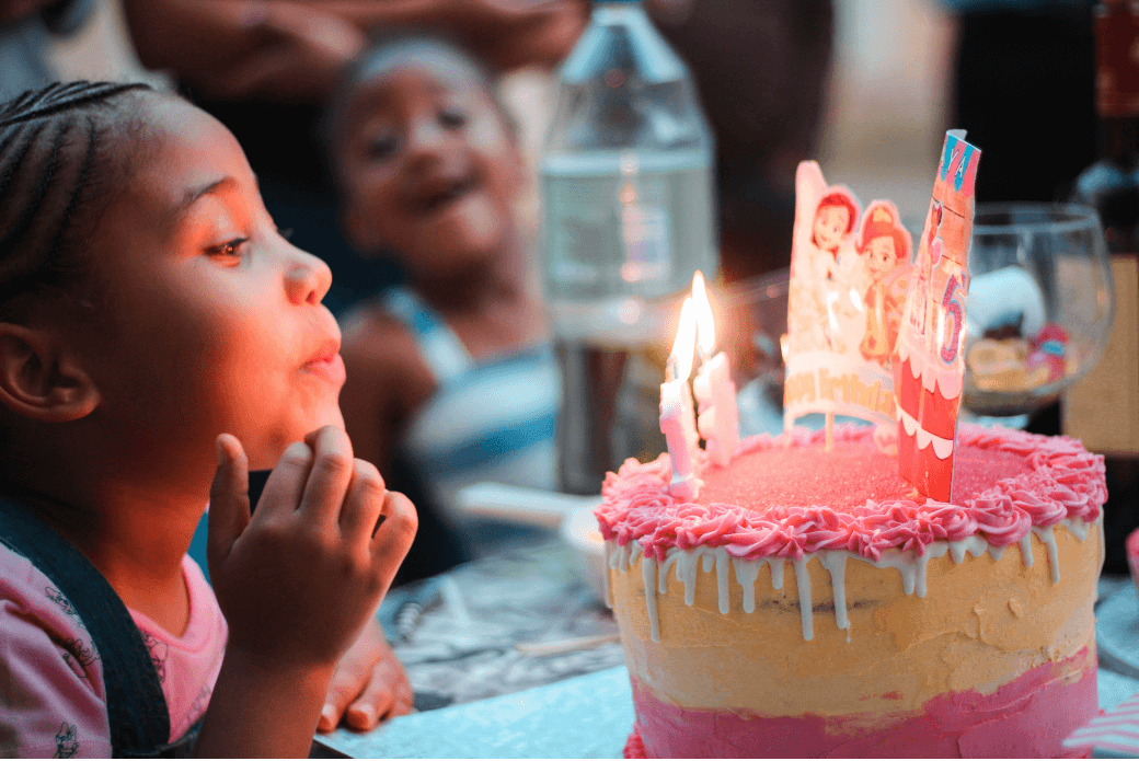 Girl blowing out candles on cake