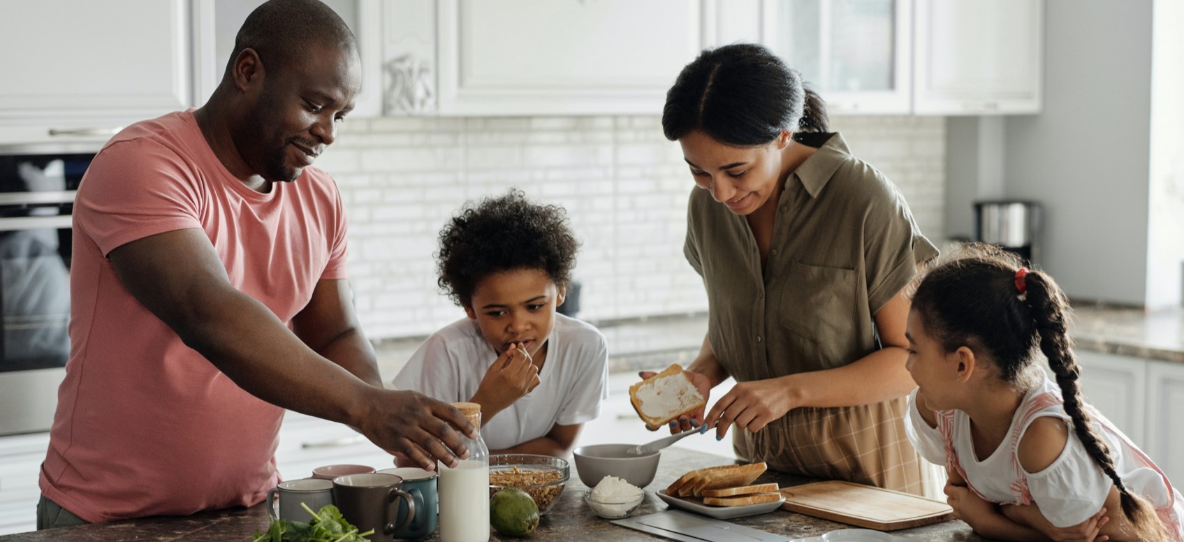 A family of four preparing food at home