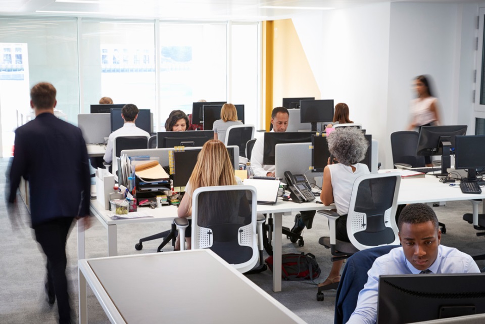 Man walking through a busy open plan office